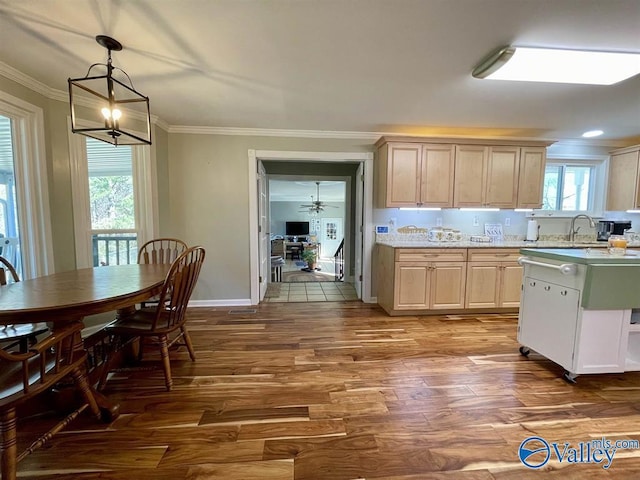 kitchen featuring decorative light fixtures, ornamental molding, light countertops, light brown cabinetry, and dark wood-style floors