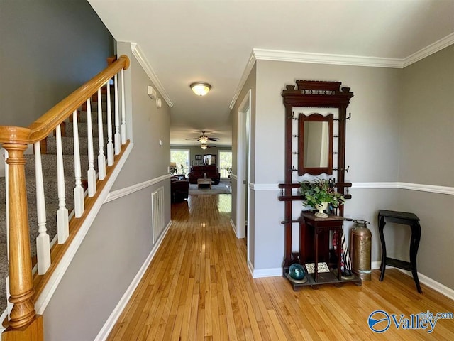 hallway with stairway, baseboards, hardwood / wood-style floors, and crown molding