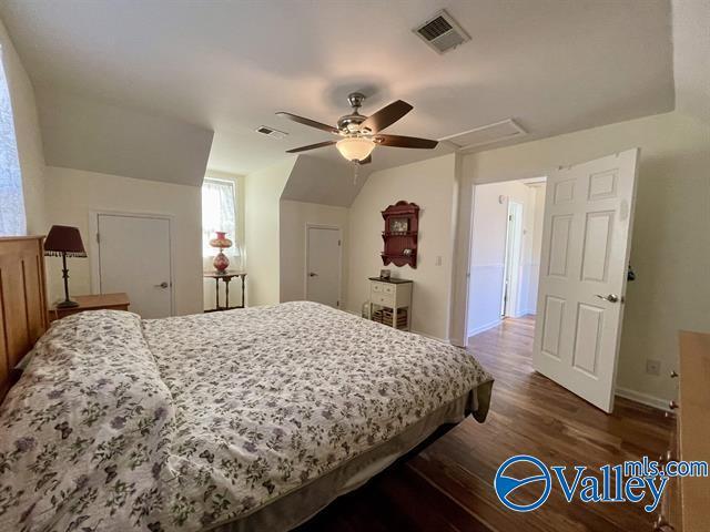 bedroom featuring visible vents, ceiling fan, baseboards, and dark wood-style floors