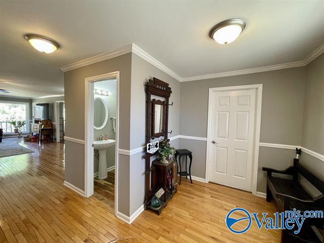 foyer entrance with baseboards, light wood-type flooring, and ornamental molding