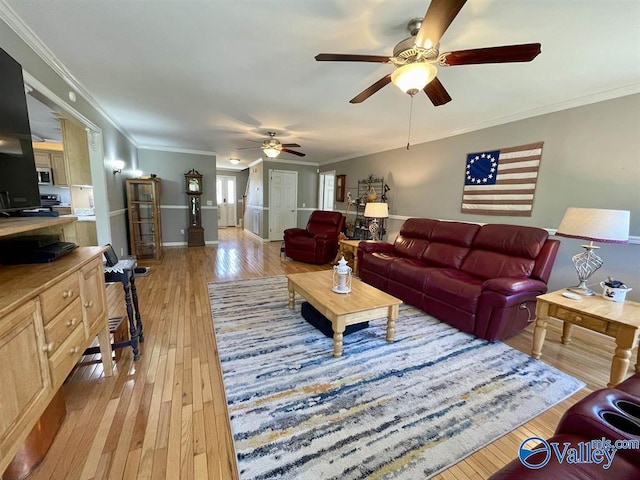 living area with light wood-type flooring, crown molding, a ceiling fan, and baseboards