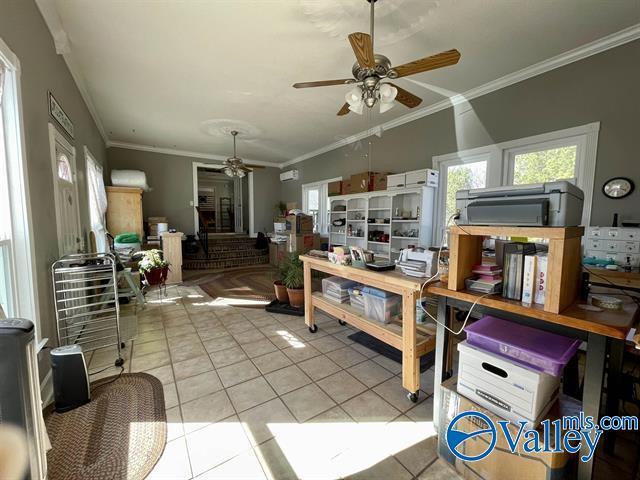 living room with crown molding, a ceiling fan, and light tile patterned flooring