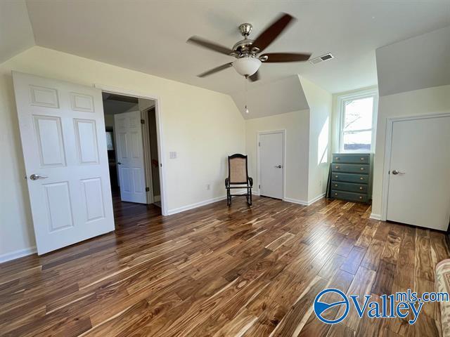 bonus room with baseboards, a ceiling fan, visible vents, lofted ceiling, and wood finished floors