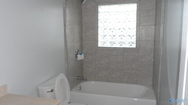 full bathroom with vanity, tiled shower / bath combo, and toilet