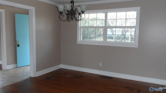 unfurnished dining area with dark wood-type flooring, an inviting chandelier, and ornamental molding