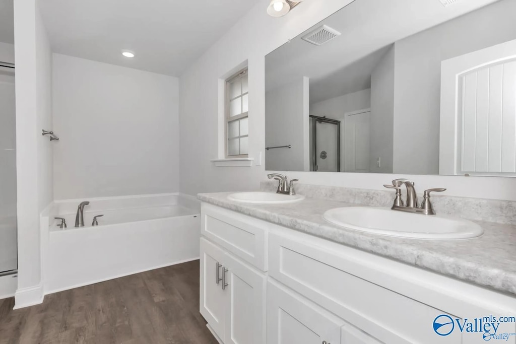 bathroom with separate shower and tub, hardwood / wood-style floors, and vanity