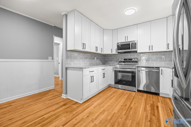 10012 Allison Dr, Huntsville, AL 35803 - kitchen featuring stainless steel appliances, light wood-style floors, white cabinetry, light stone countertops, and tasteful backsplash