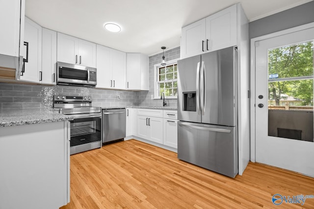 10012 Allison Dr, Huntsville, AL 35803 - kitchen with stainless steel appliances, light wood finished floors, white cabinetry, and decorative backsplash