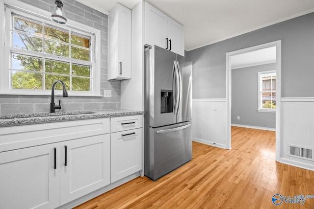 10012 Allison Dr, Huntsville, AL 35803 - kitchen featuring stainless steel refrigerator with ice dispenser, a sink, white cabinetry, light wood finished floors, and wainscoting