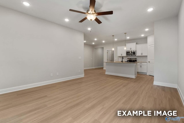 433 Lando Cain Rd, Hartselle, AL 35640 - unfurnished living room featuring ceiling fan, baseboards, light wood-style floors, recessed lighting, and a sink