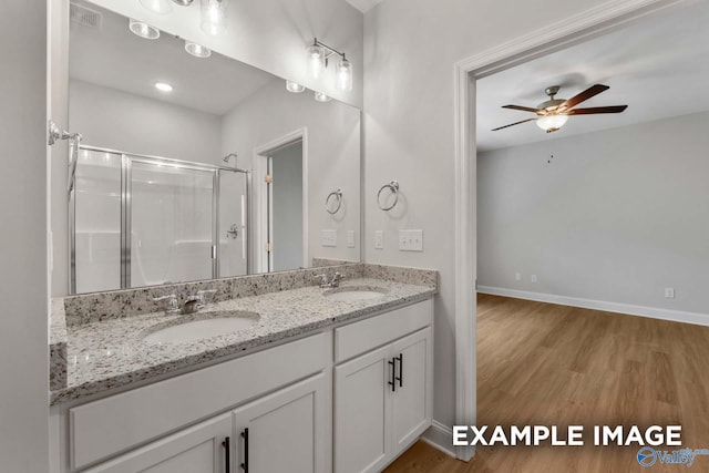 433 Lando Cain Rd, Hartselle, AL 35640 - bathroom featuring wood finished floors, a shower stall, a ceiling fan, double vanity, and baseboards