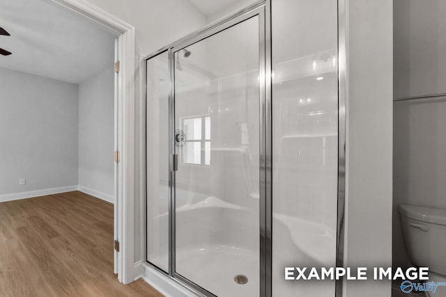 433 Lando Cain Rd, Hartselle, AL 35640 - bathroom featuring a shower stall, wood finished floors, ceiling fan, toilet, and baseboards