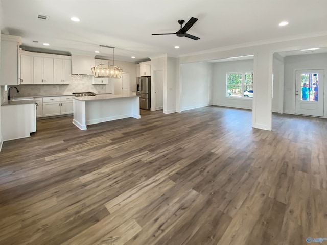 kitchen with a kitchen island, dark hardwood / wood-style flooring, stainless steel refrigerator with ice dispenser, and ceiling fan