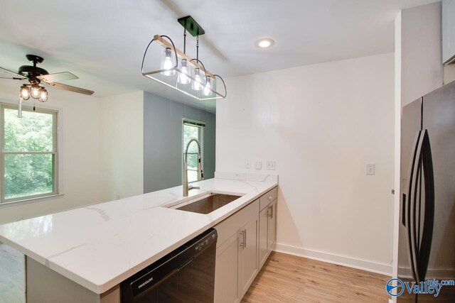 kitchen with pendant lighting, stainless steel fridge with ice dispenser, black dishwasher, light hardwood / wood-style floors, and kitchen peninsula