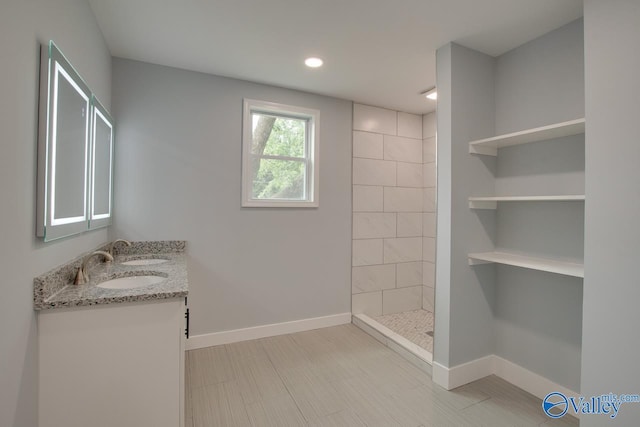 3913 Pine Ave SW, Huntsville, AL 35805 - bathroom featuring a sink, double vanity, recessed lighting, baseboards, and tiled shower