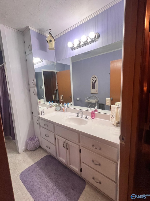 bathroom with vanity, tile patterned floors, a textured ceiling, and crown molding