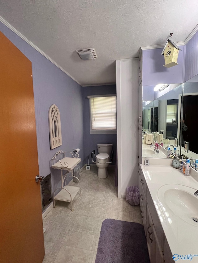 bathroom featuring a textured ceiling, tile patterned floors, toilet, vanity, and ornamental molding