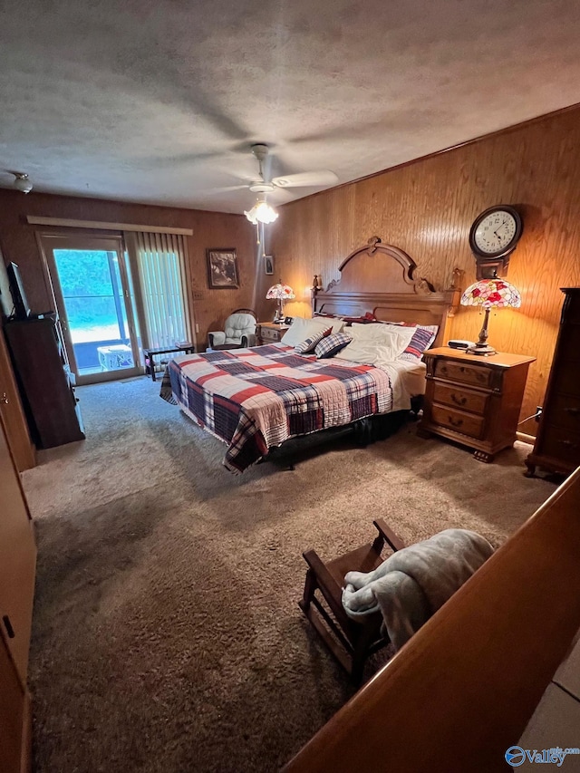 bedroom featuring ceiling fan, wood walls, carpet, a textured ceiling, and access to exterior