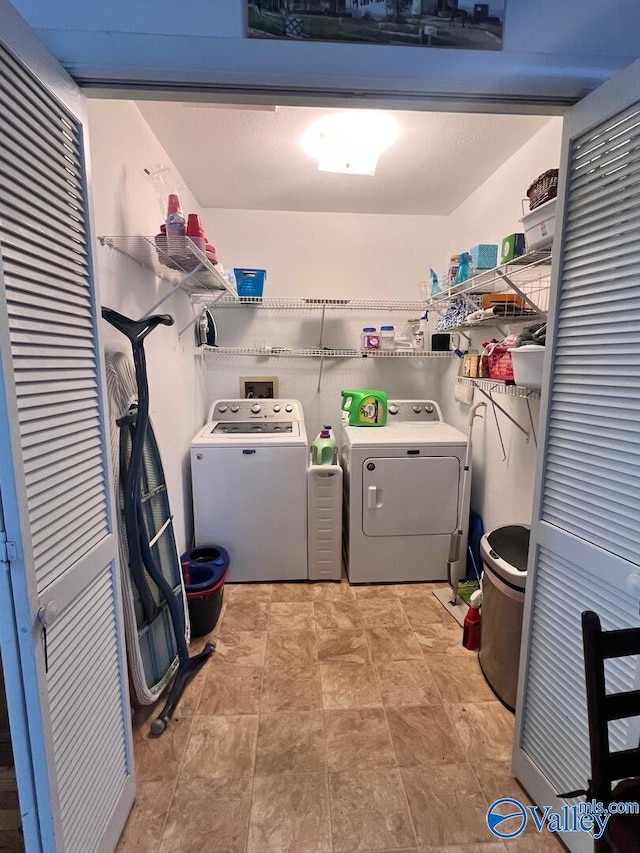 clothes washing area with separate washer and dryer and light tile patterned floors