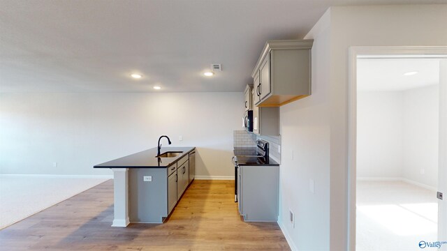 kitchen with tasteful backsplash, light wood-type flooring, sink, and gray cabinetry