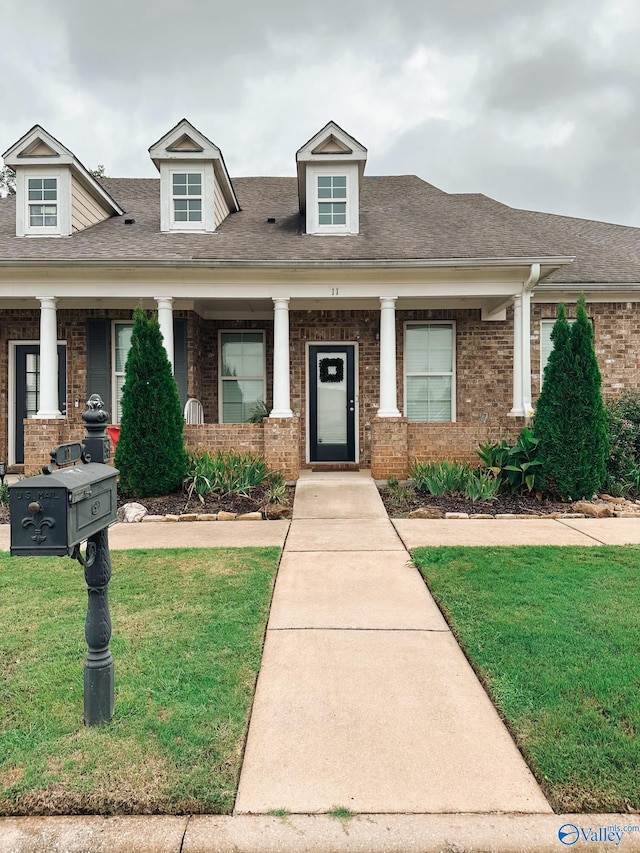 view of front of home featuring covered porch and a front yard