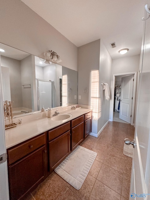 bathroom featuring tile patterned floors, vanity, and a shower with door