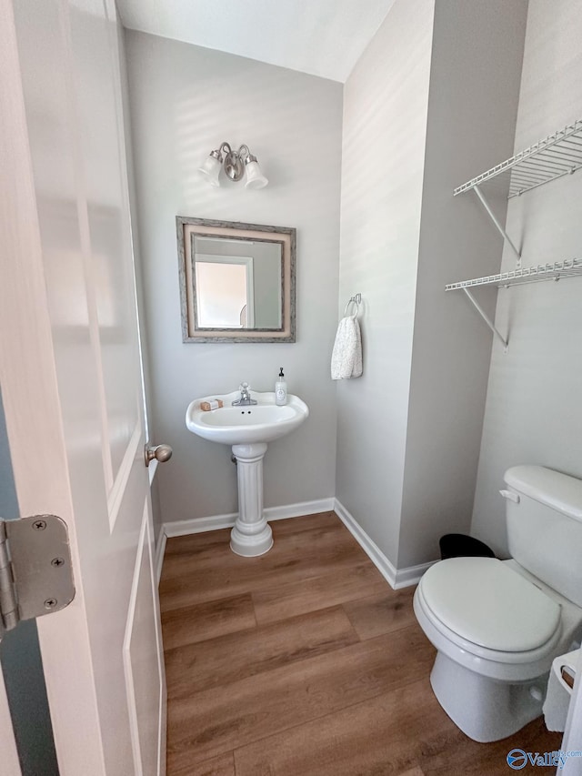 bathroom with hardwood / wood-style floors and toilet