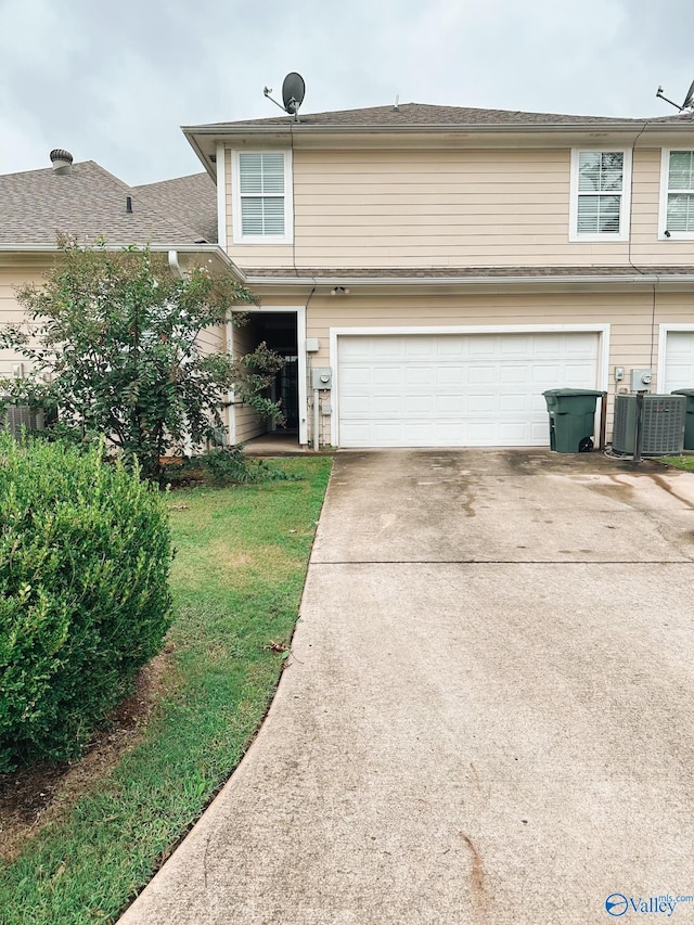 view of front of property featuring a garage and central AC