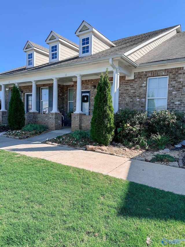 view of front of home with a porch and a front yard