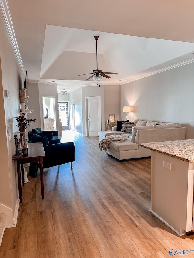 living room with crown molding, lofted ceiling, ceiling fan, and light wood-type flooring