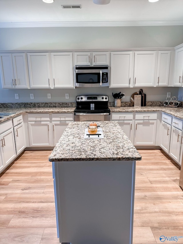 kitchen featuring a kitchen island, appliances with stainless steel finishes, and white cabinets