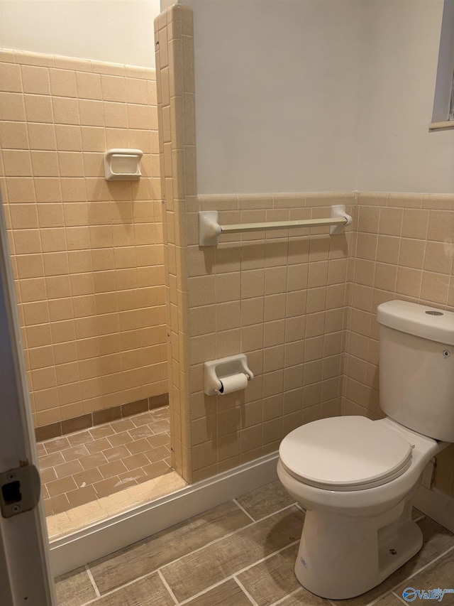 bathroom with toilet, tile walls, and walk in shower