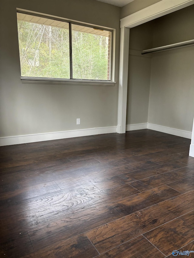 unfurnished bedroom featuring dark hardwood / wood-style floors and a closet