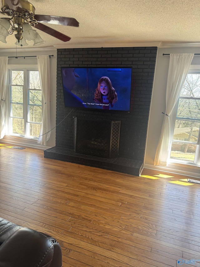 interior details with visible vents, a fireplace, a textured ceiling, and wood finished floors