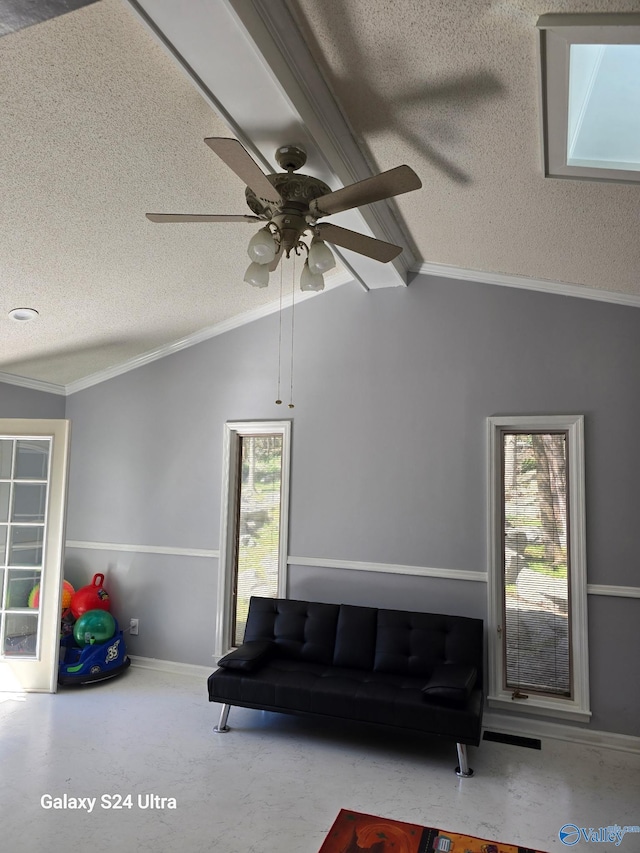 living area with a ceiling fan, plenty of natural light, a textured ceiling, and vaulted ceiling with beams