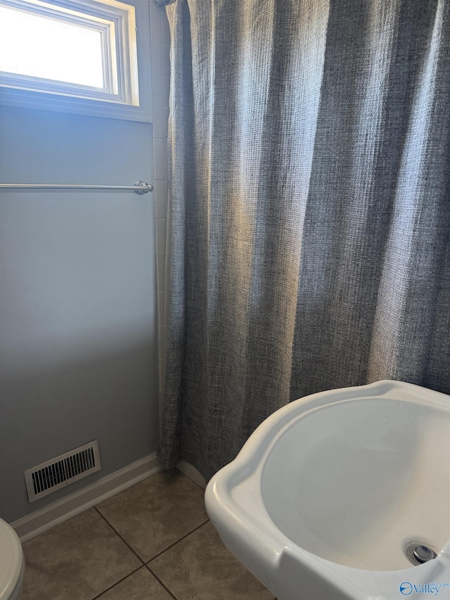 full bath featuring curtained shower, tile patterned floors, and visible vents