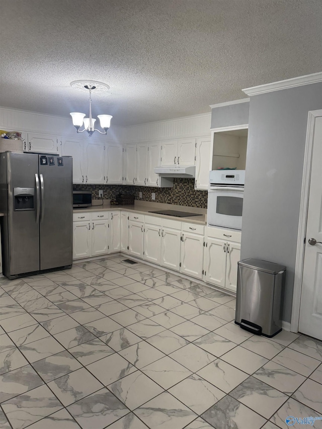 kitchen with under cabinet range hood, white cabinets, a notable chandelier, marble finish floor, and stainless steel appliances