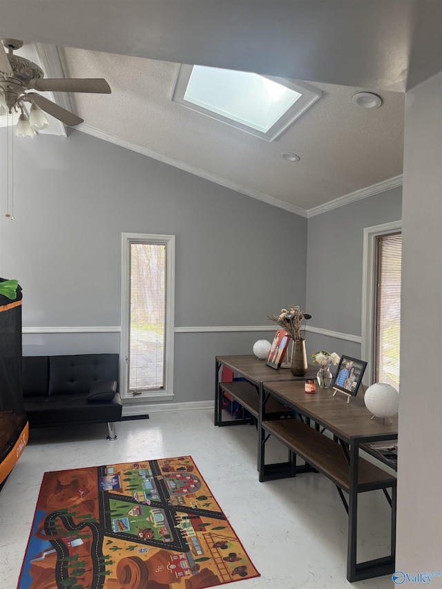 office area featuring a wealth of natural light, vaulted ceiling with skylight, a textured ceiling, and ornamental molding