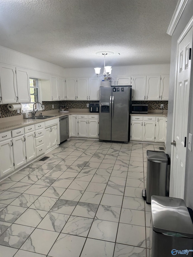 kitchen featuring decorative backsplash, marble finish floor, appliances with stainless steel finishes, and white cabinets