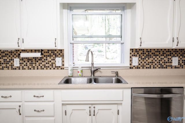 kitchen featuring a sink, tasteful backsplash, stainless steel dishwasher, and white cabinetry