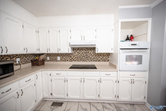 kitchen featuring stainless steel microwave, black electric stovetop, under cabinet range hood, light countertops, and white oven