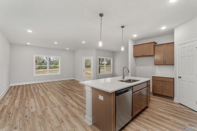 kitchen featuring sink, decorative light fixtures, dishwasher, an island with sink, and light hardwood / wood-style floors