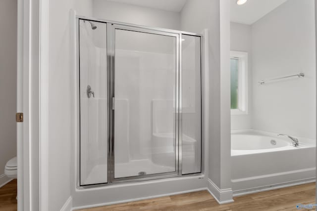 bathroom with hardwood / wood-style flooring and independent shower and bath