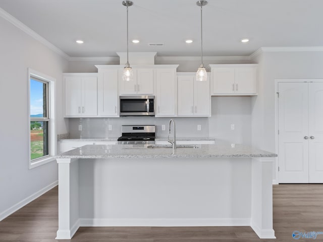 kitchen featuring appliances with stainless steel finishes, pendant lighting, white cabinetry, and light stone countertops