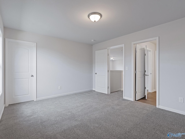 unfurnished bedroom with a walk in closet, dark carpet, and a closet