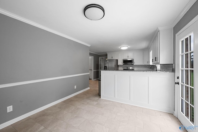 127 Patdean Dr, Huntsville, AL 35811 - kitchen with appliances with stainless steel finishes, stone countertops, ornamental molding, and white cabinetry