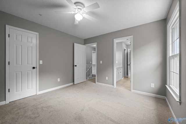 127 Patdean Dr, Huntsville, AL 35811 - unfurnished bedroom featuring light colored carpet, multiple windows, a textured ceiling, and connected bathroom