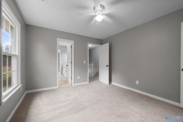 127 Patdean Dr, Huntsville, AL 35811 - unfurnished bedroom with light carpet, multiple windows, a textured ceiling, ensuite bathroom, and ceiling fan