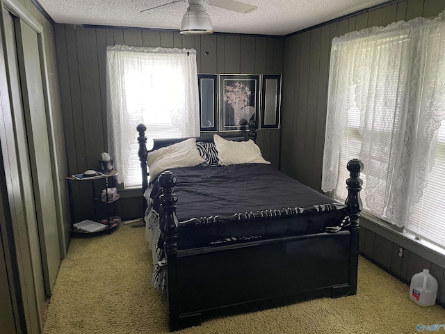 bedroom featuring a textured ceiling, a ceiling fan, and light colored carpet