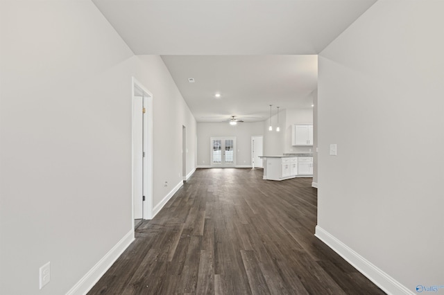 corridor with french doors, baseboards, and dark wood-style floors